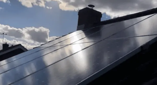 Solar panels on a roof in the day.